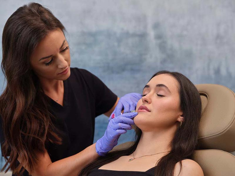 woman getting filler injection in lip