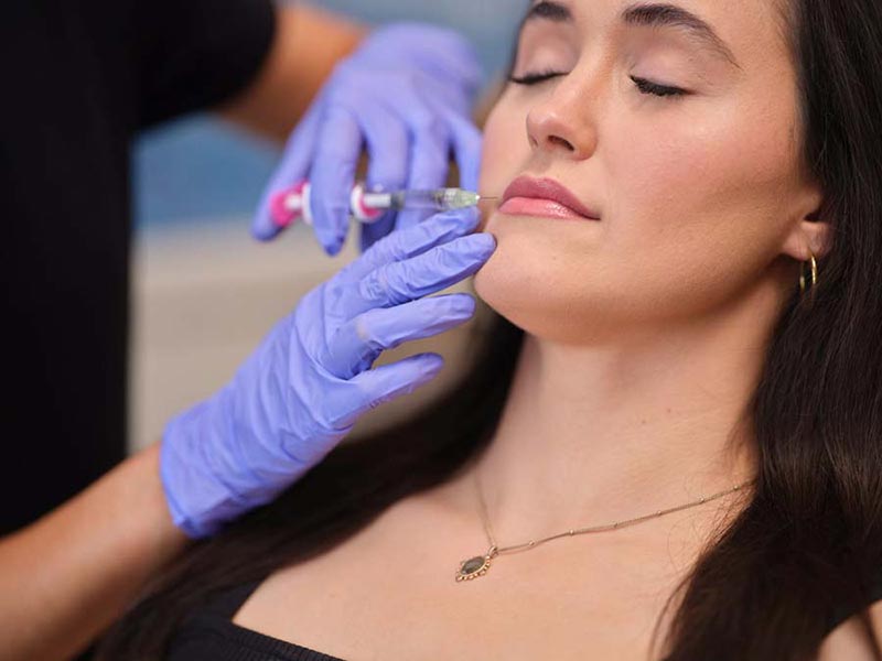 woman getting filler injection in lip