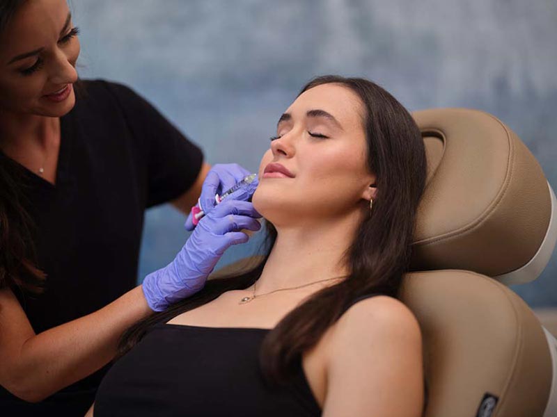 woman getting filler injection in lip