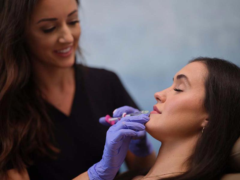 woman getting filler injection in lip